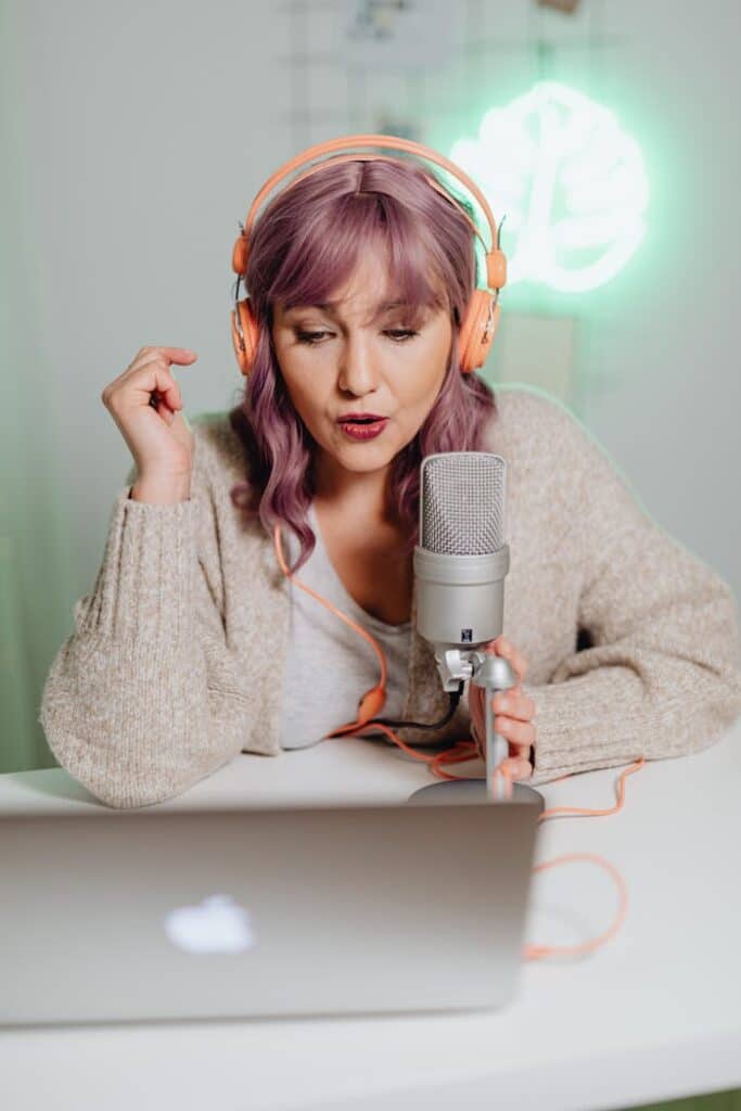 pexels-photo-6919951 A woman wearing headphones, podcasting with a professional microphone and laptop.